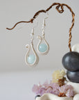 Side angle view of aquamarine drop earrings, showing intricate wire wrapping and soft silver finish, March birthstone