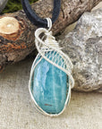 Close-up of polished aquamarine pendant front, artisan wire wrapped in 925 sterling silver, men's necklace