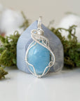 Close-up of aquamarine pendant front, polished gemstone in detailed 925 sterling silver wire wrapping
