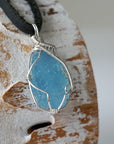 Right side view of raw aquamarine pendant showing detailed artisan wire wrapping in sterling silver, men's design