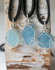 Three raw aquamarine pendants showing natural variation in size, shape, and blue color, Designs by Nature Gems, men's collection