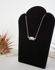 Left angle view of clear quartz and pearl bar necklace in 925 sterling silver on jewelry display