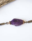 Close up of raw amethyst stone wrapped in antique bronze copper, men’s amethyst bracelet on black leather cord