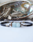 Detailed front angle of men's aquamarine bracelet, genuine faceted aquamarine, artisan wire wrapping, antique bronze finish, black leather