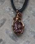 Back view of a men’s garnet wire wrapped pendant necklace in antique bronze copper, highlighting the handcrafted wire work
