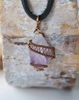 Front view of men’s raw amethyst crystal pendant wire wrapped in antique bronze copper on black leather cord, February birthstone