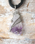 Detailed front view of men’s raw amethyst pendant wire wrapped in white gold plated copper on black leather cord