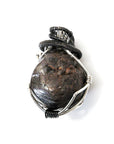 Front view of a men’s wire wrapped garnet pendant necklace featuring a natural garnet wrapped in mixed metal copper wire