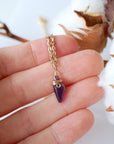 Minimalist amethyst necklace for women shown in hand for size reference, gold plated copper wire wrap