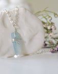 Right side angle of minimalist aquamarine necklace, showing genuine aquamarine pendant and soft silver finish over copper wire