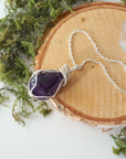 Natural dark amethyst pendant necklace on sterling silver chain, flat lay product photo