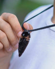 Men’s black obsidian arrowhead necklace with antique bronze copper wire wrap on male model, handcrafted by Designs by Nature Gems.