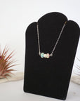 Left angle view of opal and pearl bar necklace in 925 sterling silver on jewelry display
