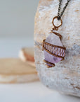 Left side detail of raw amethyst point pendant necklace with antique bronze copper wire wrap on antique bronze chain