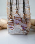 Three raw amethyst point pendant necklaces on antique bronze chain showing natural variation in crystal color, size, and shape