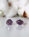Detailed front view of raw amethyst stud earrings, unpolished natural amethyst stones on sterling silver posts