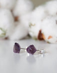 Side angle view of raw amethyst stud earrings, unpolished natural amethyst stones, sterling silver posts