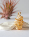 Side angle view of raw citrine pendant showing crystal dimension and wire wrapping detail - natural unpolished stone in gold plated copper handmade jewelry