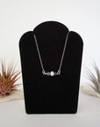 Sapphire and freshwater pearl bar necklace in 925 sterling silver on jewelry display, front view