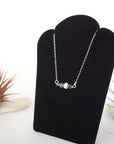 Left angle view of sapphire and pearl bar necklace in 925 sterling silver on jewelry display