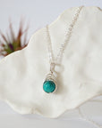 Left side angle of silver plated turquoise necklace showing wire wrap detail