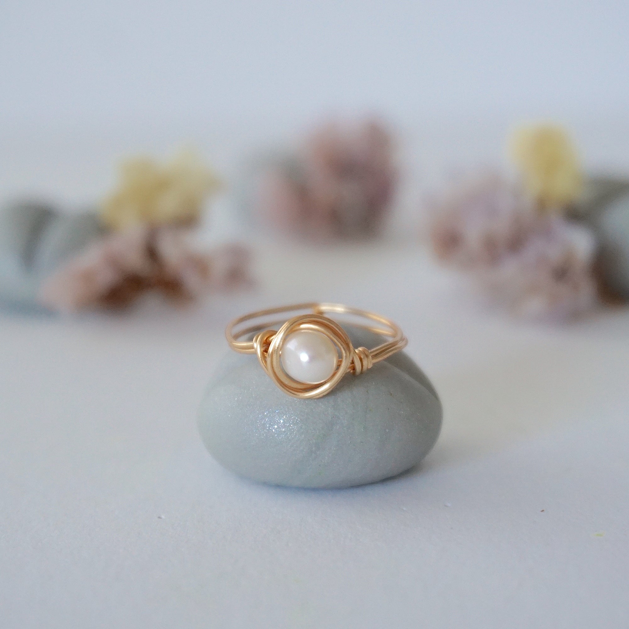 Front view of a minimalist pearl wire wrapped ring in 14k gold filled wire