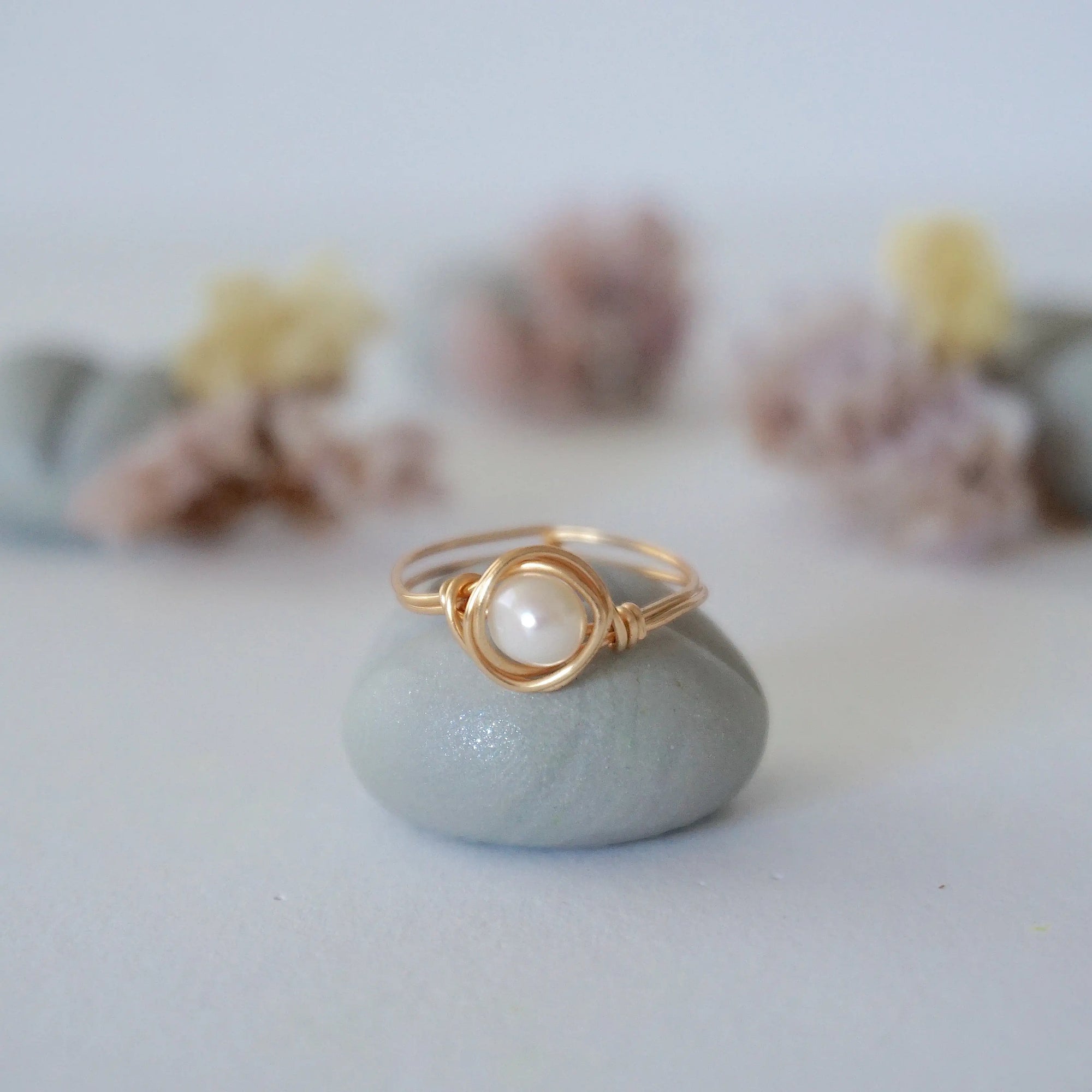 Front view of a minimalist pearl wire wrapped ring in 14k gold filled wire