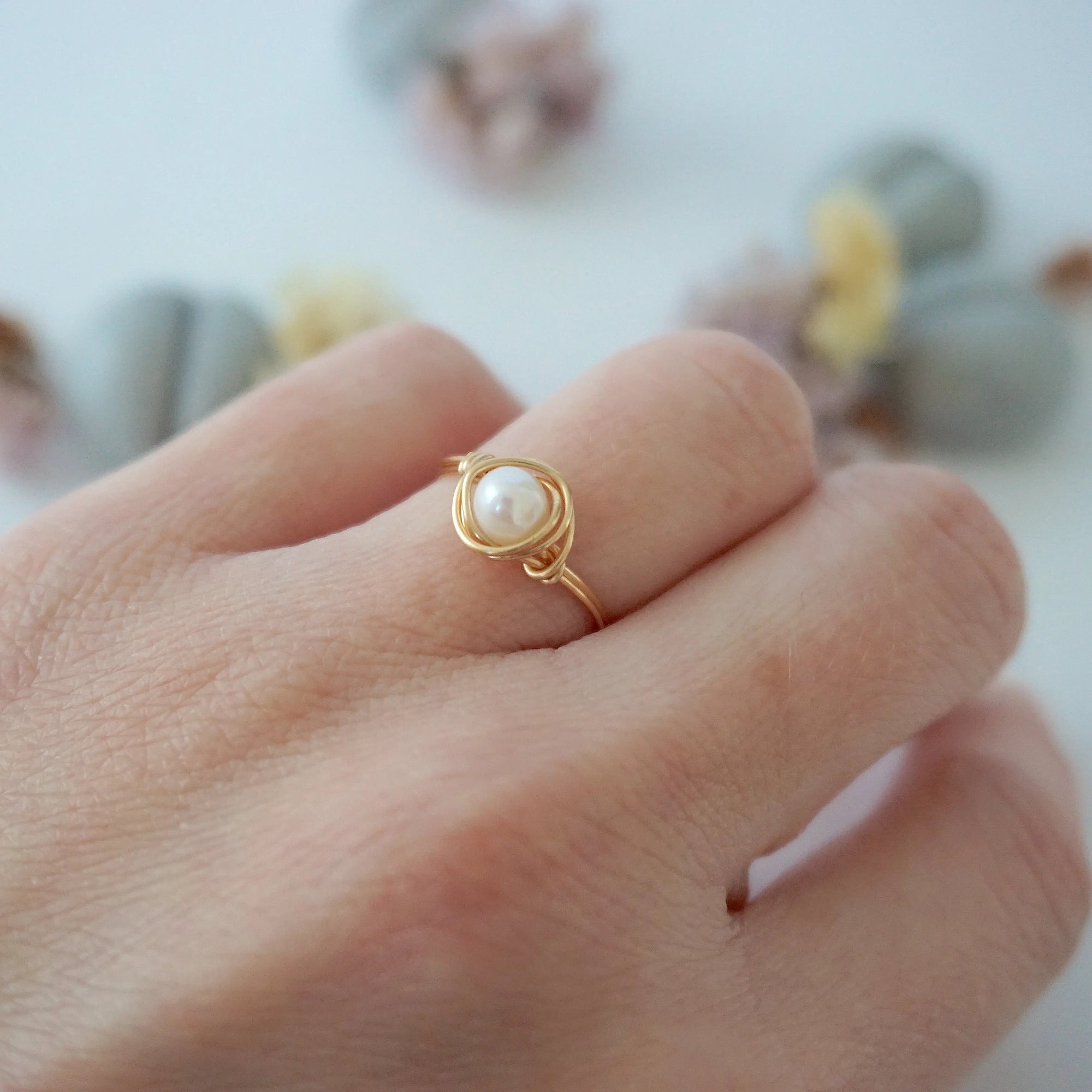 Minimalist 14k gold filled pearl wire wrapped ring worn on a model’s hand