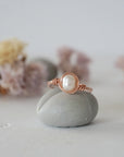Front view of a minimalist pearl wire wrapped ring in 14k rose gold filled wire