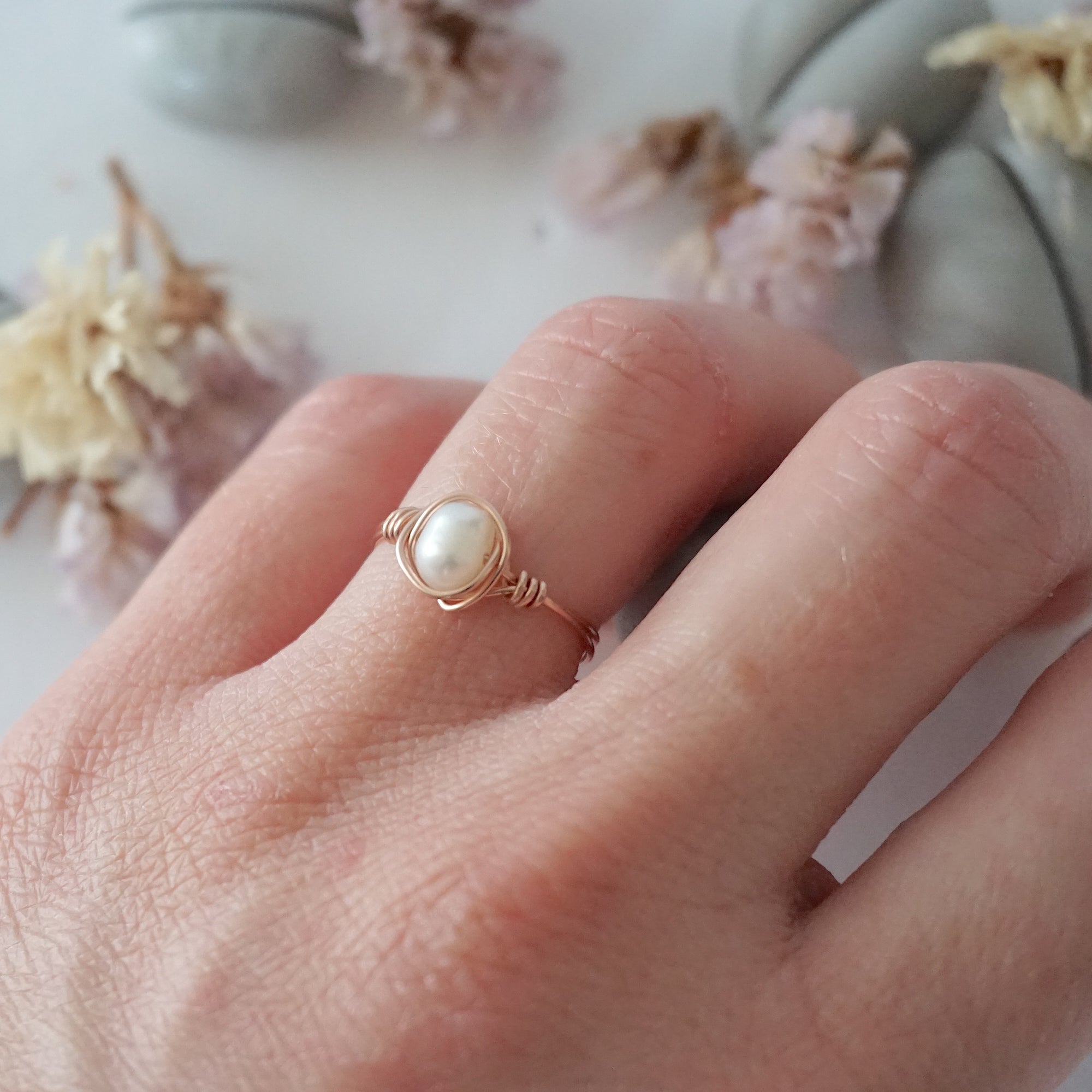 Minimalist 14k rose gold filled pearl wire wrapped ring worn on a model’s hand