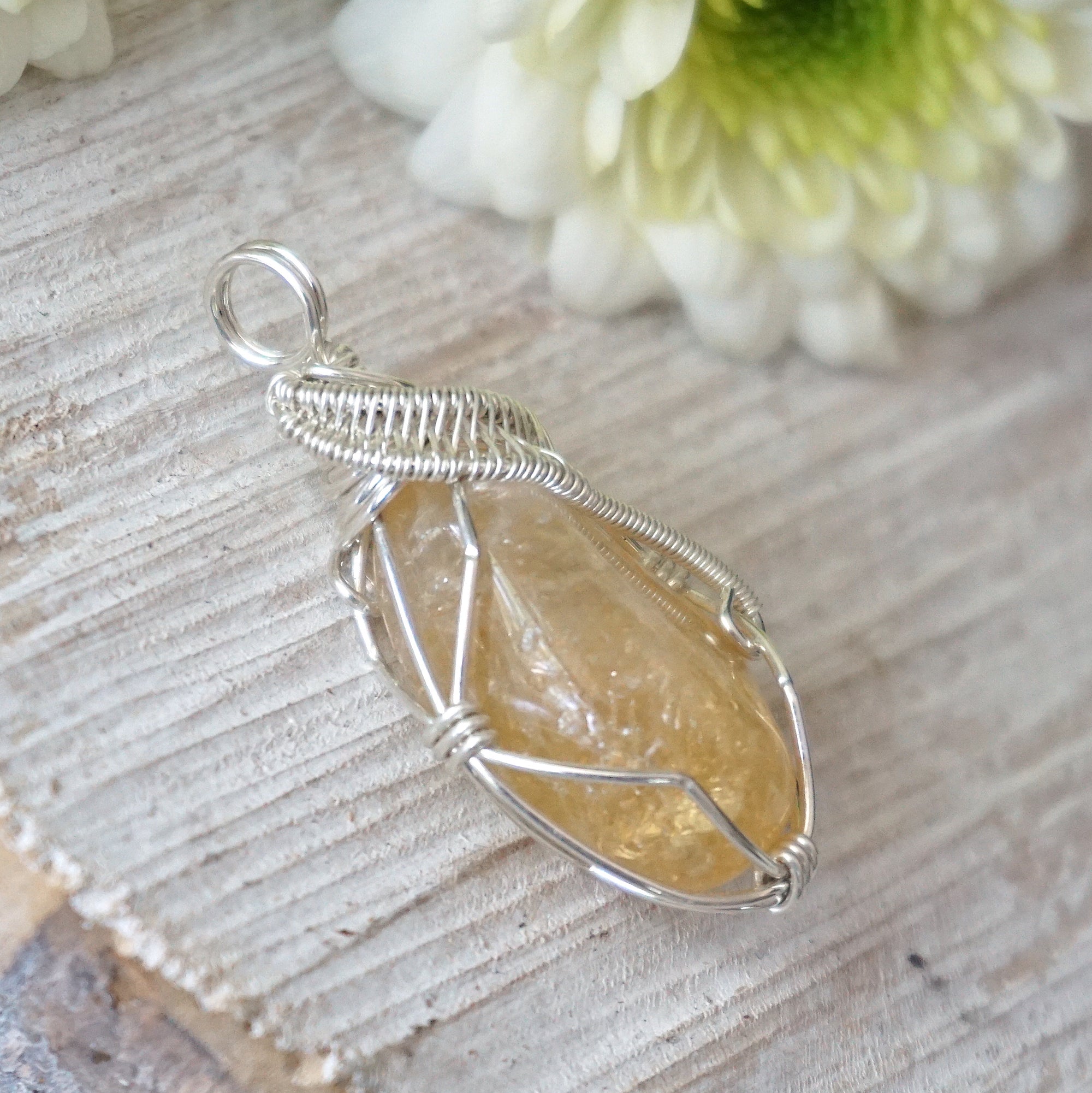 Side angle of wire wrapped citrine pendant in sterling silver showing artisan craftsmanship and stone depth
