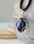 Left angle close-up of men's black onyx necklace – highlighting unique wire-wrapped artistry, black onyx, flat black leather cord.