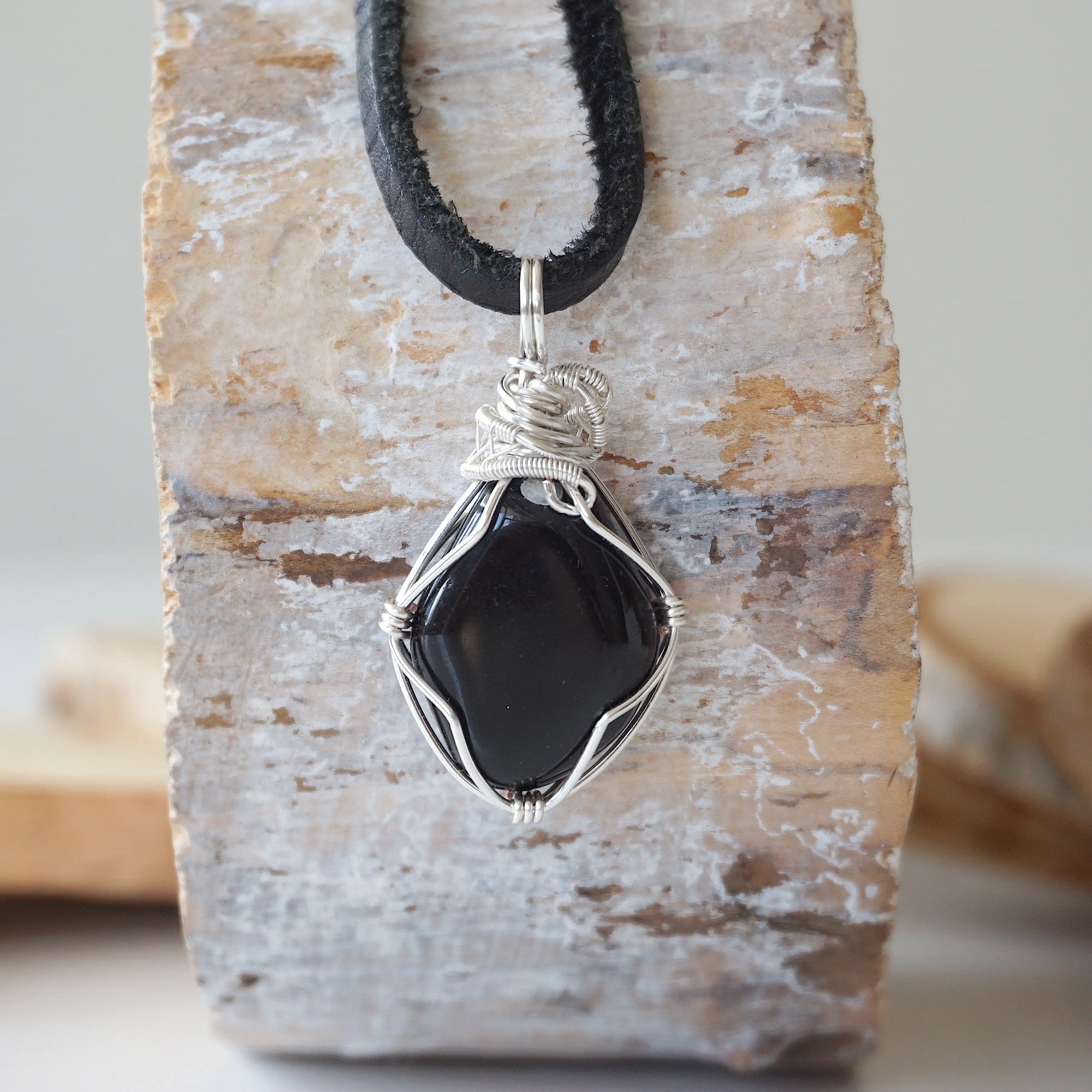 Back view of handcrafted men's black onyx necklace – natural stone and wire wrapping, July birthstone, flat black leather cord.