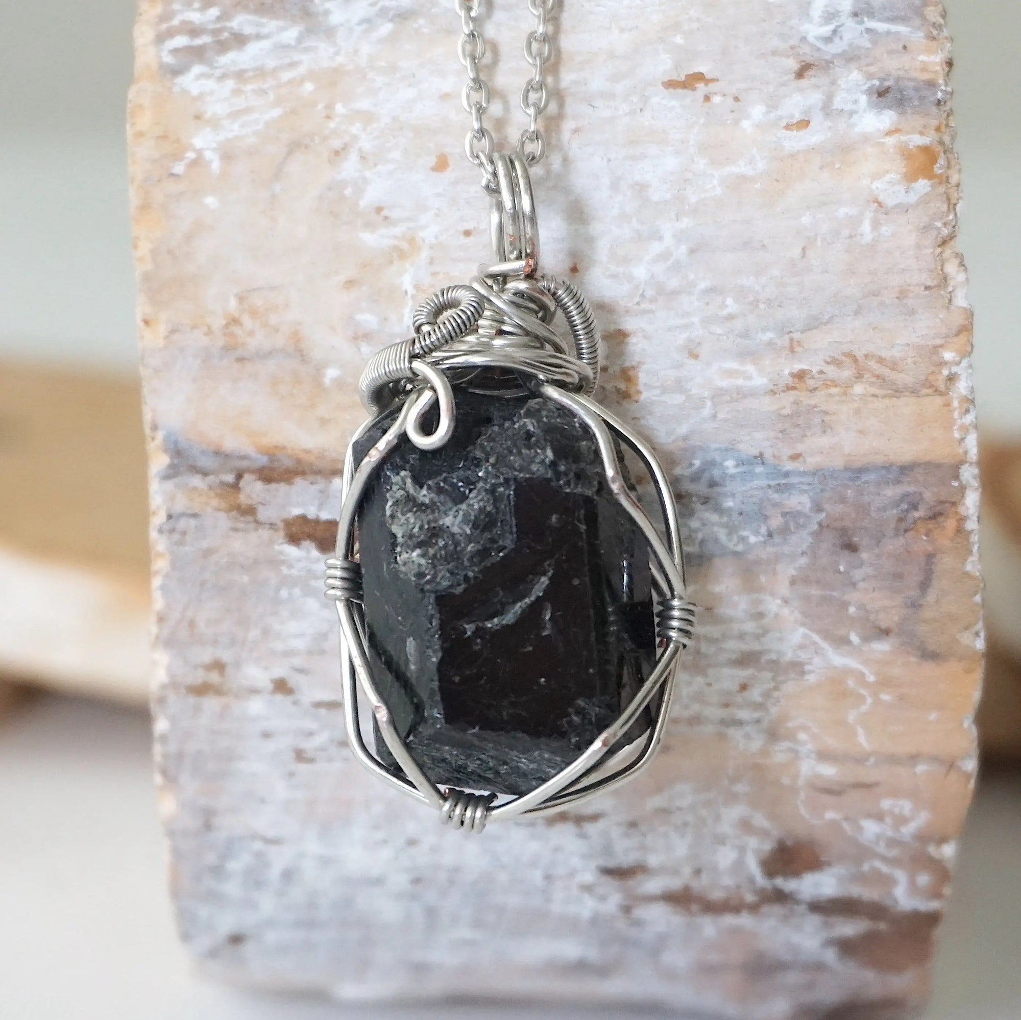 Back angle view of raw black tourmaline necklace for men – showcases wire wrapping and natural stone matrix.