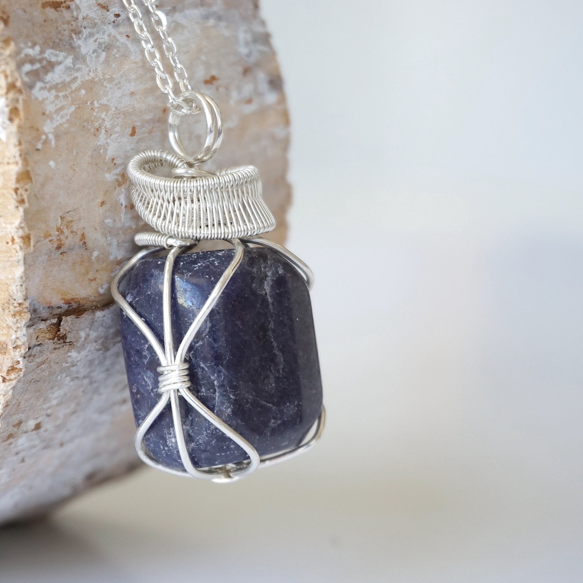 Right angle close-up of sapphire necklace for men – detailed 925 sterling silver wire wrapping, genuine sapphire, September birthstone.