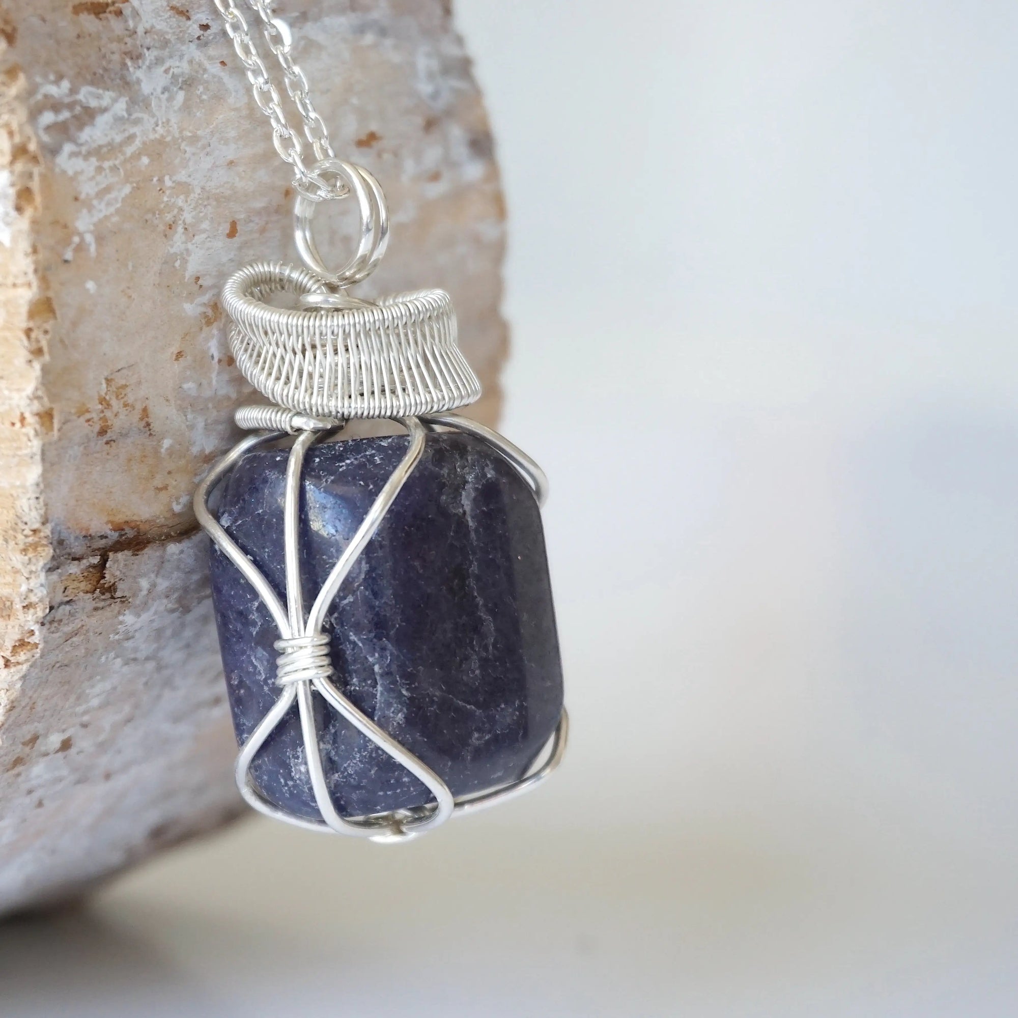 Right angle close-up of sapphire necklace for men – detailed 925 sterling silver wire wrapping, genuine sapphire, September birthstone.