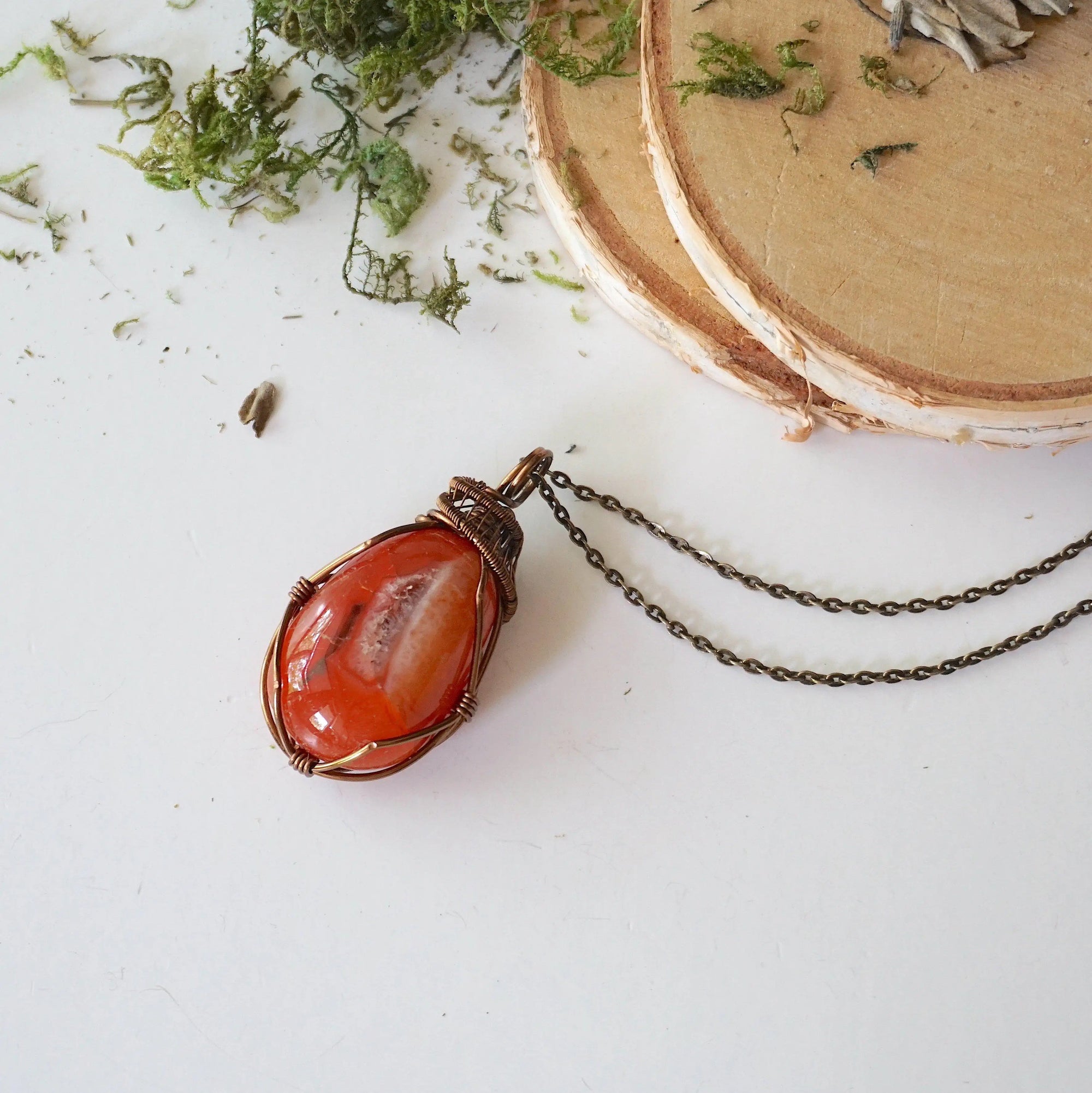 Handcrafted raw carnelian necklace laying flat – artisan bronze copper wire wrapping, Virgo zodiac birthstone jewelry for all genders, Designs by Nature Gems.