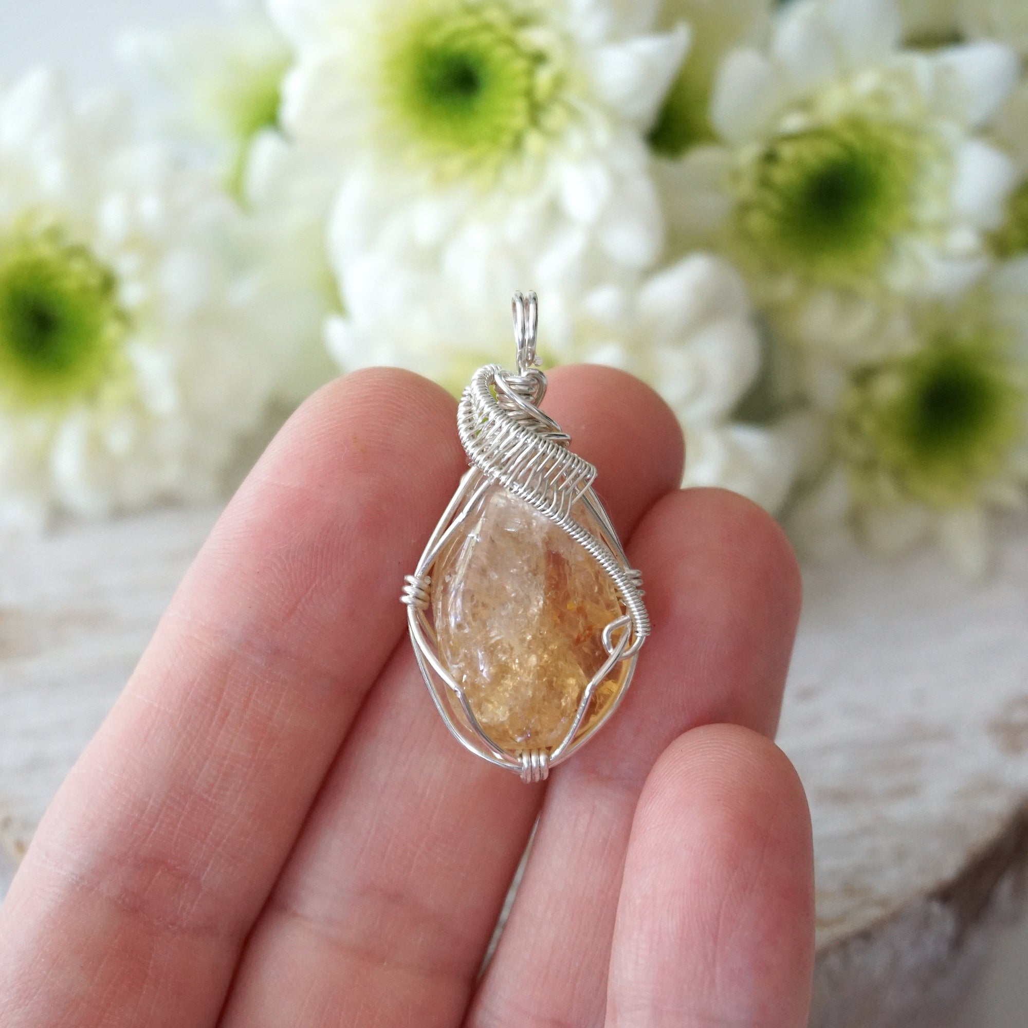 Raw citrine pendant necklace held in hand showing size of wire wrapped sterling silver jewelry November birthstone
