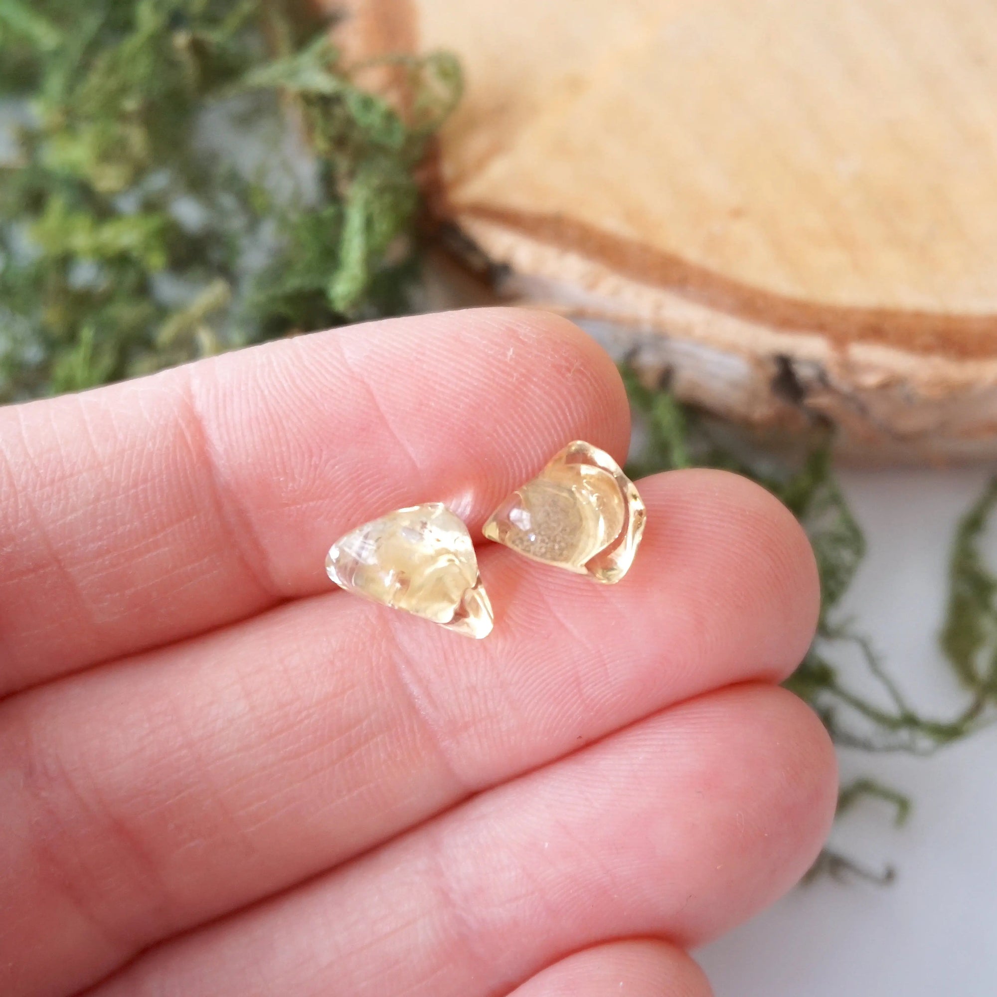 Natural citrine stud earrings held in hand showing size comparison - unisex raw crystal sterling silver studs

