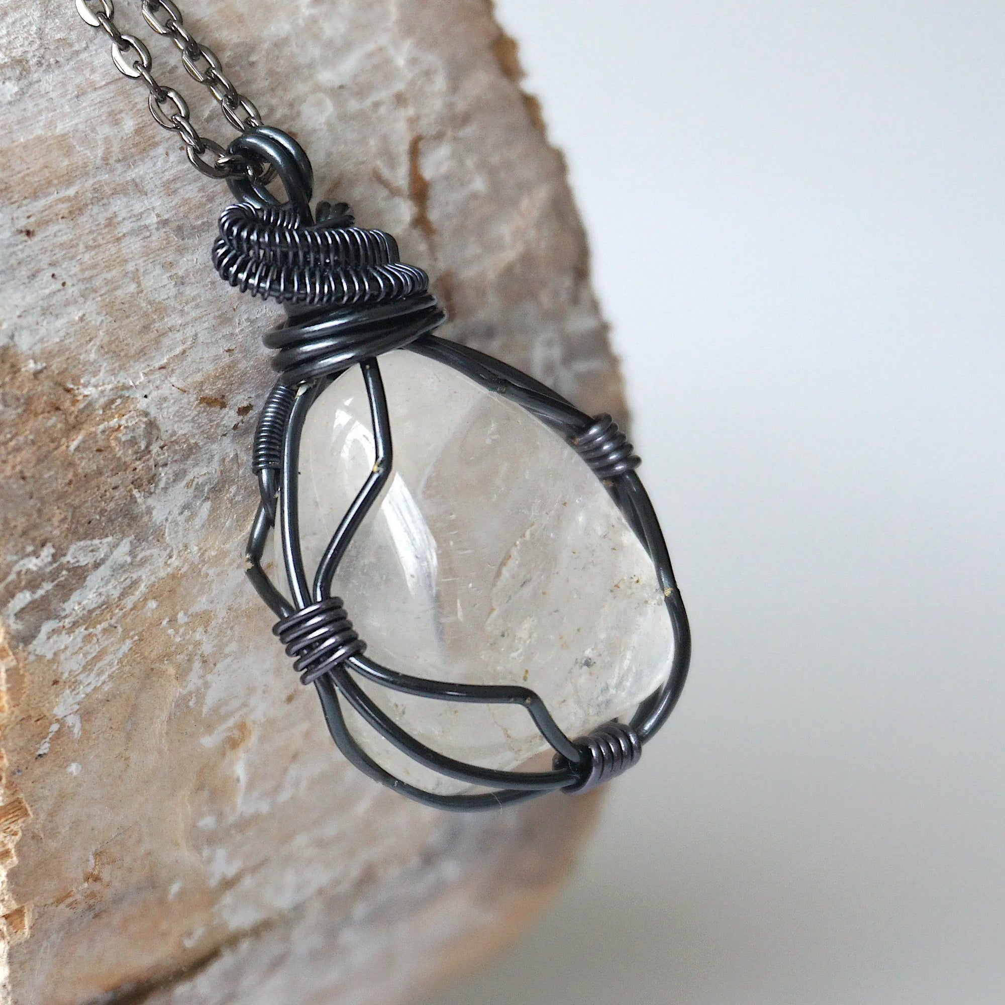 Right angle close-up of clear quartz pendant for men – showcasing artisan wire wrapped gunmetal copper, natural crystal.
