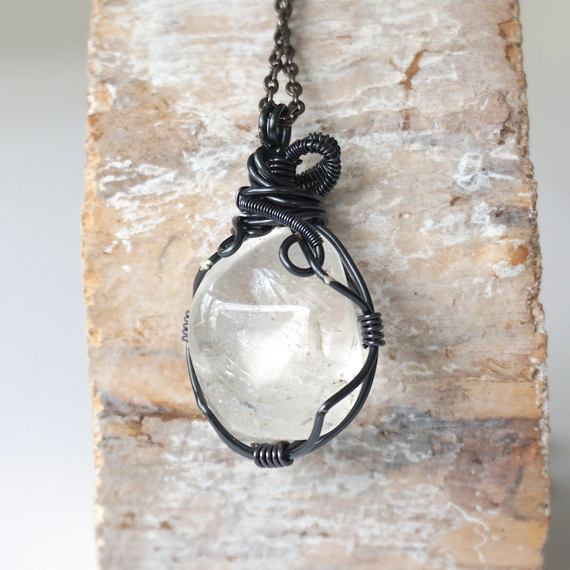 Back view of handcrafted clear quartz pendant for men – natural stone and detailed wire wrapping, April birthstone.