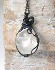 Back view of handcrafted clear quartz pendant for men – natural stone and detailed wire wrapping, April birthstone.