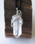 Handcrafted clear quartz point necklace for men, front view – artisan white gold copper wire wrapping, April birthstone, black leather cord.