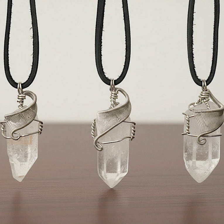 Three clear quartz point necklaces for men – showing natural variation in size, shape, white gold copper wire wrapping.