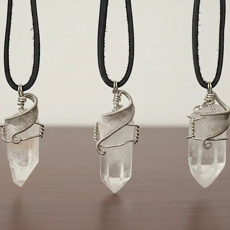 Three clear quartz point necklaces for men – showing natural variation in size, shape, white gold copper wire wrapping.