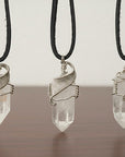 Three clear quartz point necklaces for men – showing natural variation in size, shape, white gold copper wire wrapping.