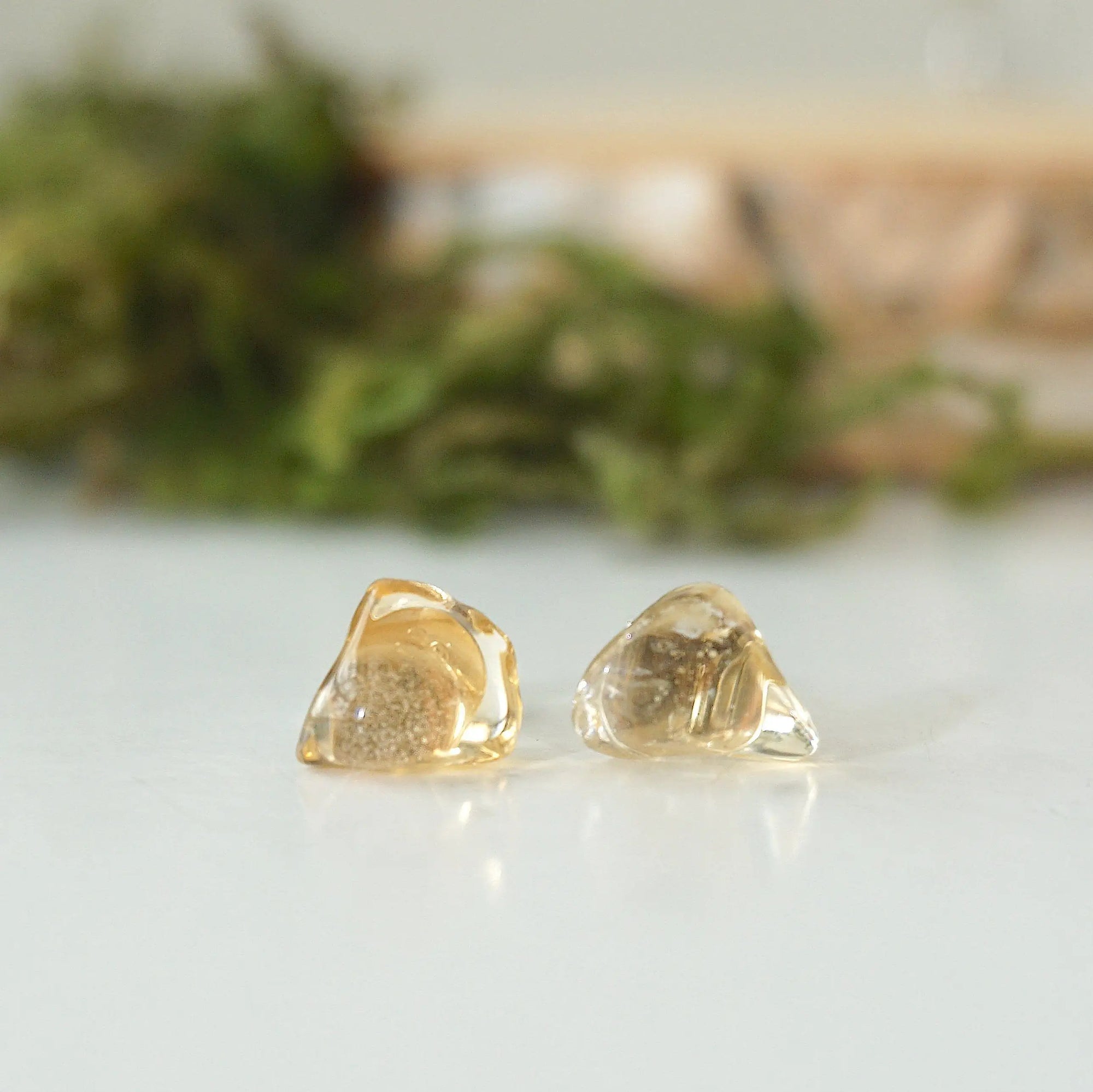 Close-up of raw unpolished citrine crystals on stud earrings showing natural golden color and organic texture
