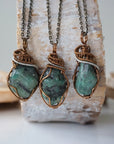 Three raw emerald pendants – showcasing natural variation in size, shape, and green shade, handcrafted unisex birthstone jewelry.