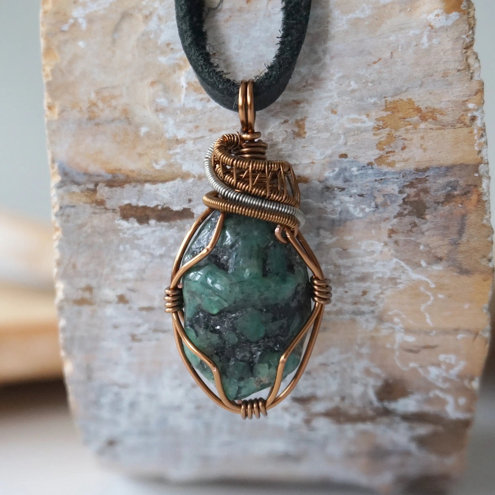 Handcrafted raw emerald necklace for men, front view – artisan bronze and silver copper wire wrapping, May birthstone, black leather cord.