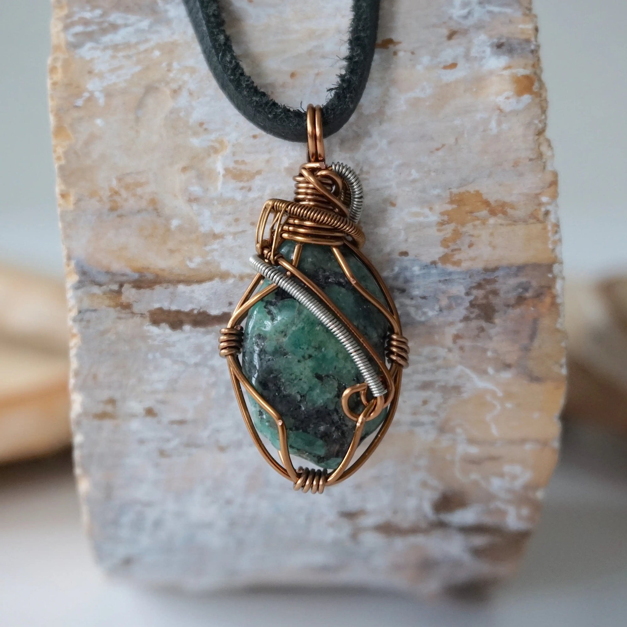 Back view of handcrafted men's emerald necklace – natural stone and wire wrapping, May birthstone, black leather cord.